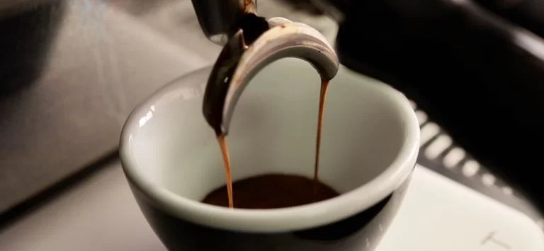 Espresso pouring into a cup at the end of extraction